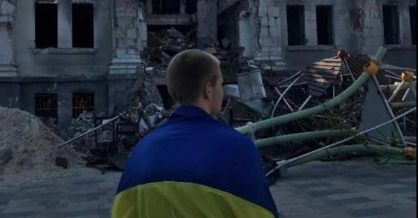 В Мариуполе юноша вышел на площадь возле разбомбленного Драмтеатра с флагом Украины - Общество